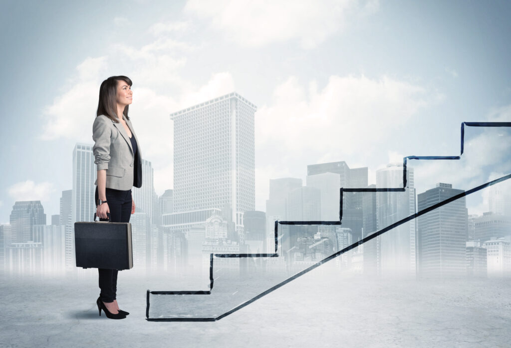 A professional woman in front of a staircase ready for career development.
